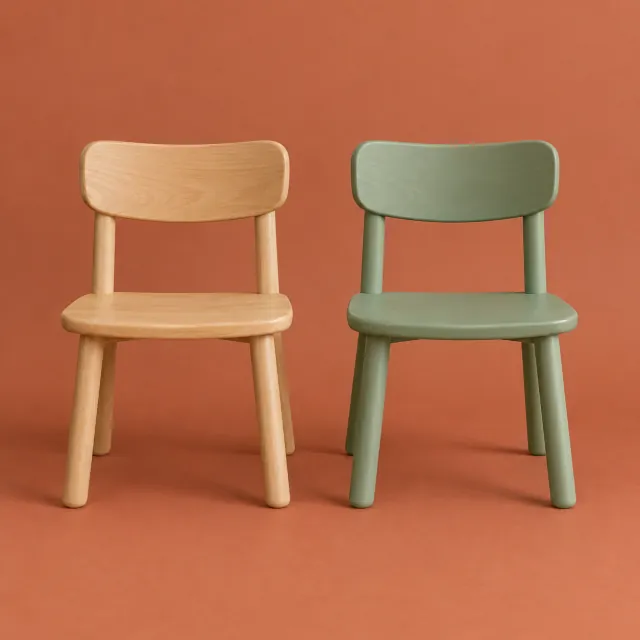 Dos sillas infantiles de haya con respaldo curvado, una natural y otra pintada en verde salvia, sobre fondo terracota de estudio